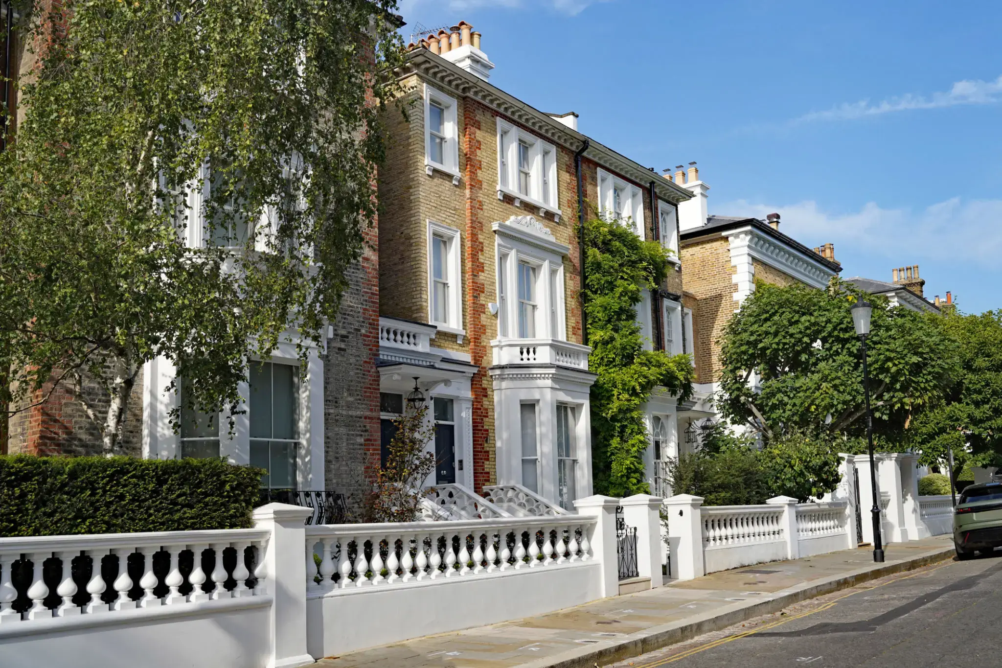 Row of elegant townhouses on sunny street.