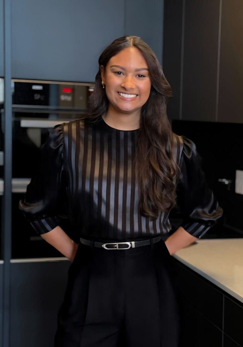 Smiling woman standing in modern kitchen.